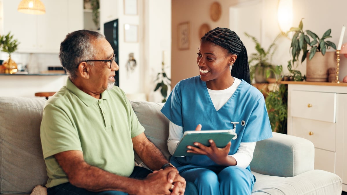A caregiver and an older adult sharing a warm moment together at home